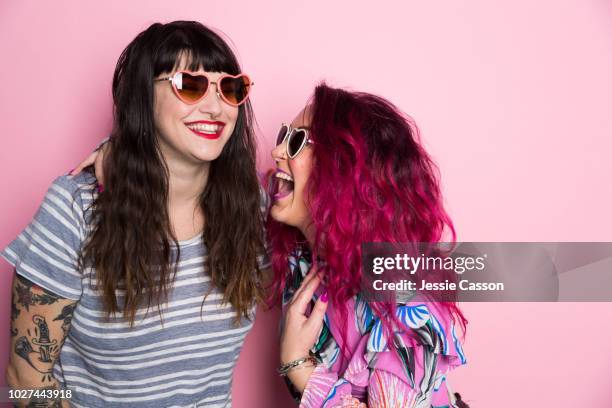 two woman laughing against a pink back ground - friends women makeup stockfoto's en -beelden