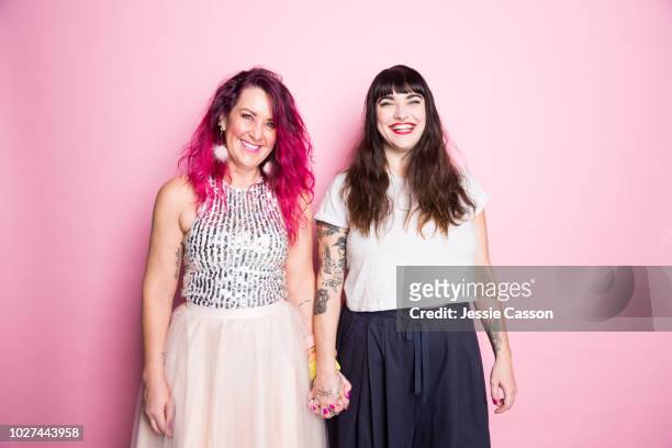 two woman stand together holding hands - lesbische stock-fotos und bilder