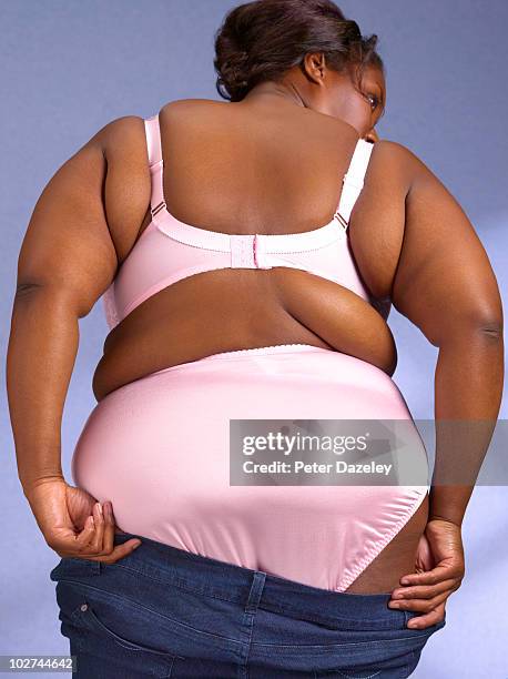 over weight woman pulling up jeans - woman bum stock-fotos und bilder
