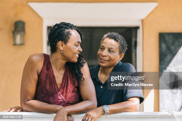 loving lesbian couple posing on the porch - gay seniors stock pictures, royalty-free photos & images