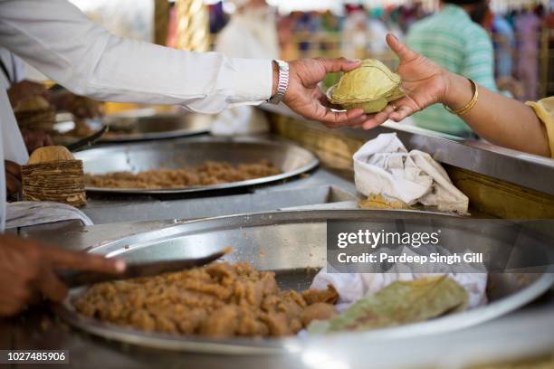 pilgrims receive karah-prasad (holy offering) at the golden temple (also known as sri harmandir sahib gurdwara) during the vaisakhi festival in amritsar, punjab, india - amritsar - fotografias e filmes do acervo