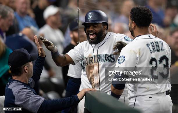 Denard Span of the Seattle Mariners is congratulated by hitting coach Edgar Martinez and Nelson Cruz of the Seattle Mariners after hitting solo home...