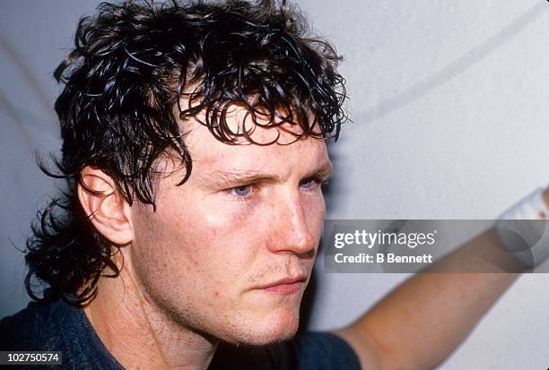 Bob Probert of the Detroit Red Wings talks to reporters in the locker room after an NHL game circa 1991.