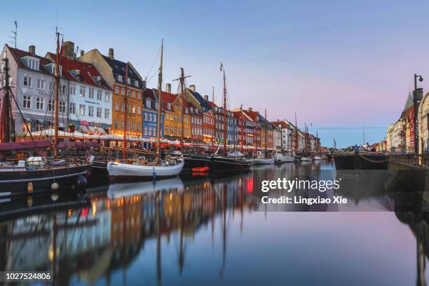 colorful buildings along nyhavn (new harbour) at dusk, copenhagen, denmark - copenhagen nyhavn stock pictures, royalty-free photos & images