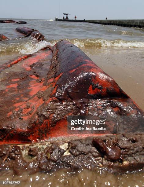 An oil coated containment boom is seen on the beach after it was moved out of place high winds and waves in the past days which brought oil ashore...