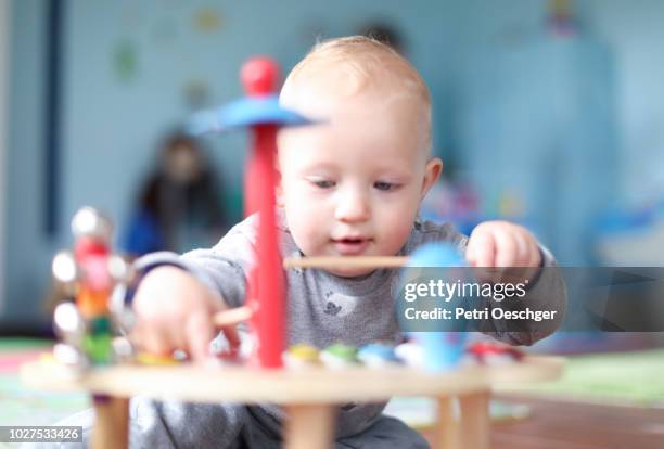 a baby boy playing a xylophone. - xylophone photos et images de collection