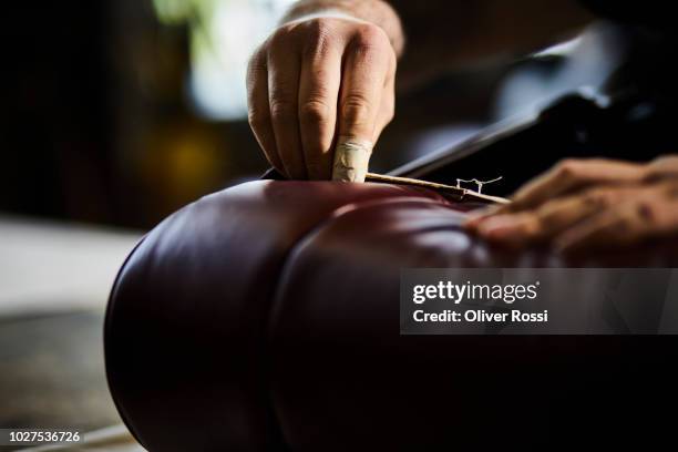 close-up of man in an automobile upholstery workshop restoring seat - leather seat stock pictures, royalty-free photos & images