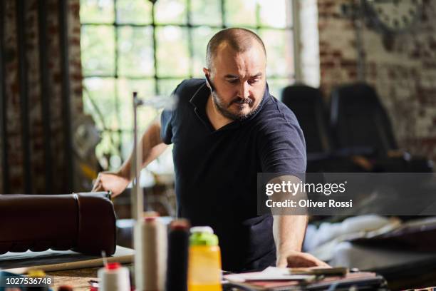 man working in an automobile upholstery workshop - saddler stock pictures, royalty-free photos & images