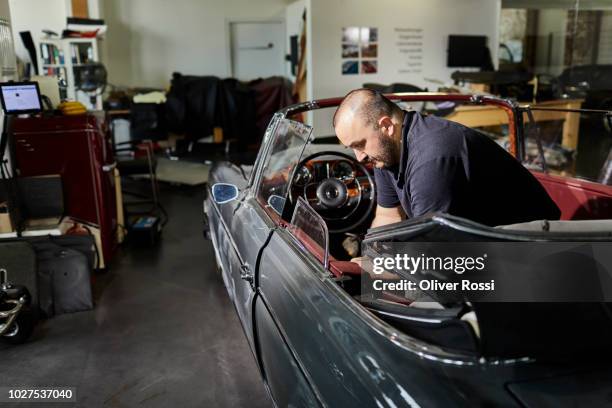 man working on vintage car in an automobile upholstery workshop - old fashioned car stock pictures, royalty-free photos & images