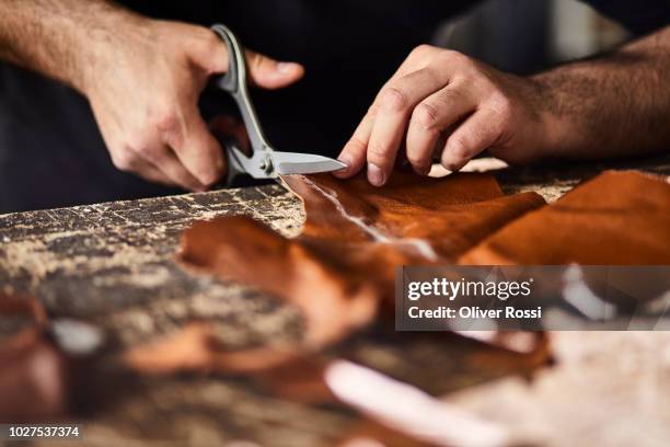 close-up of man cutting leather in workshop - artisan photos et images de collection