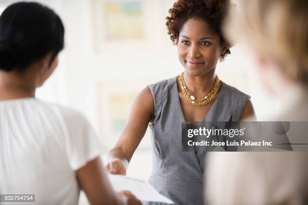 black businesswoman in meeting with co-workers - giving back bildbanksfoton och bilder