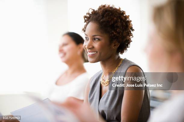 black businesswoman listening in meeting - multikulturalismus stock-fotos und bilder