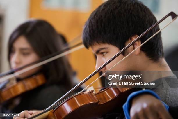 students practicing in high school orchestra - orchestra rehearsal stock pictures, royalty-free photos & images