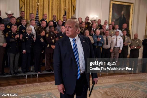President Donald Trump pauses to listen a question from a reporter regarding The New York Times' anonymous op-ed after a meeting with sheriffs from...