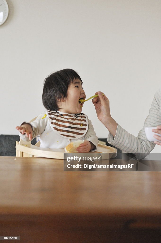 Mother feeding baby boy