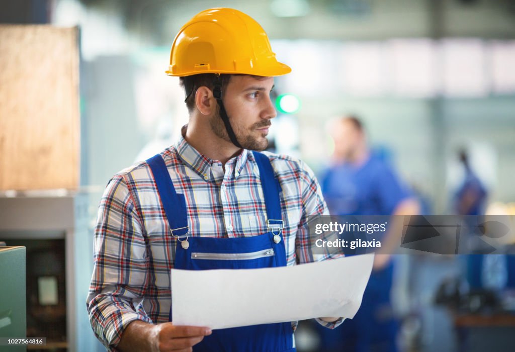 Factory employee contemplating.