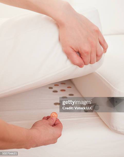 hiding coins under the mattress - cushion imagens e fotografias de stock