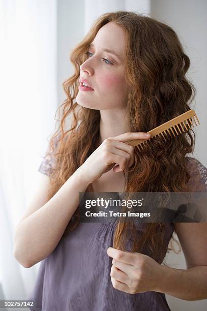 woman combing her hair - man combing hair stock-fotos und bilder