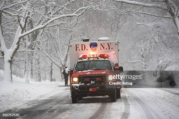 new york city fire department vehicle driving on snowy road - central park winter stock pictures, royalty-free photos & images