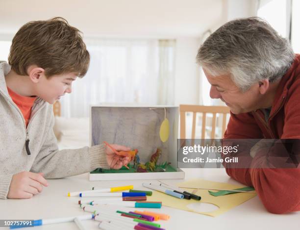 father and son working on dinosaur project - diorama stock pictures, royalty-free photos & images