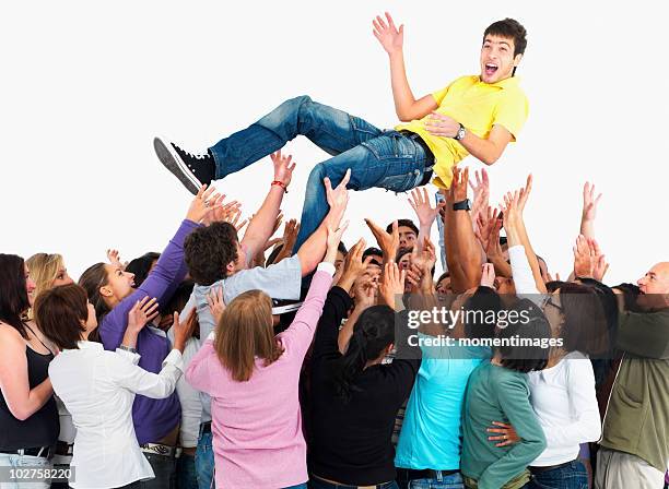 group of people carrying man - crowd surfing bildbanksfoton och bilder