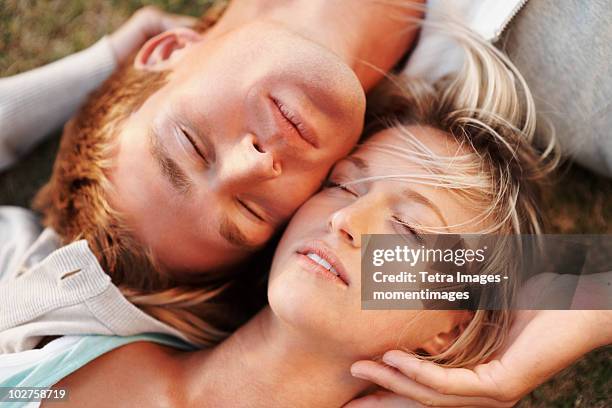 couple relaxing on the grass - im gras liegen stock-fotos und bilder