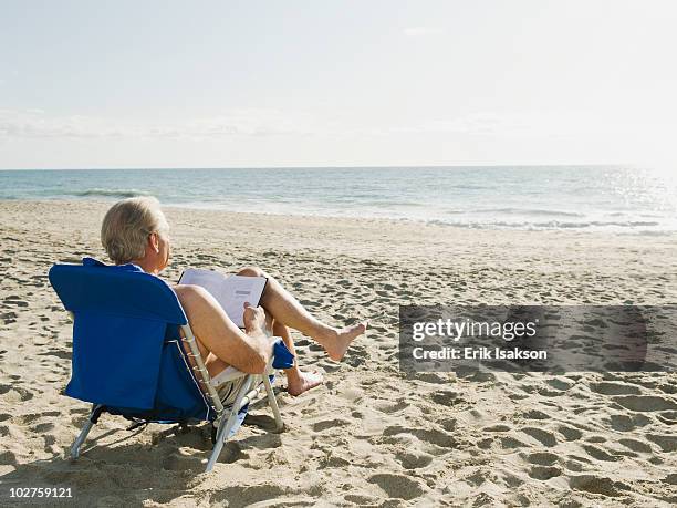 man relaxing in beach chair - reclining chair stock pictures, royalty-free photos & images