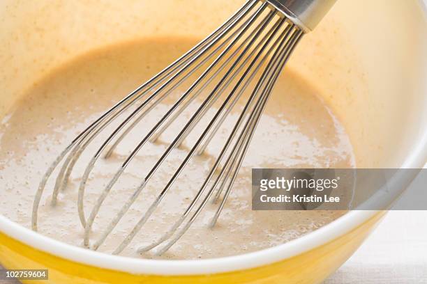 pancake batter and whisk in mixing bowl - ausbackteig stock-fotos und bilder