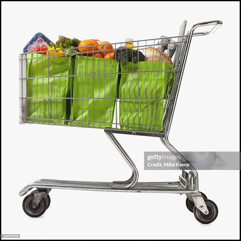 Grocery cart full of bags of groceries