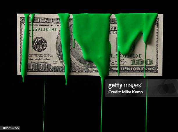 american currency covered in green paint - greed stock pictures, royalty-free photos & images