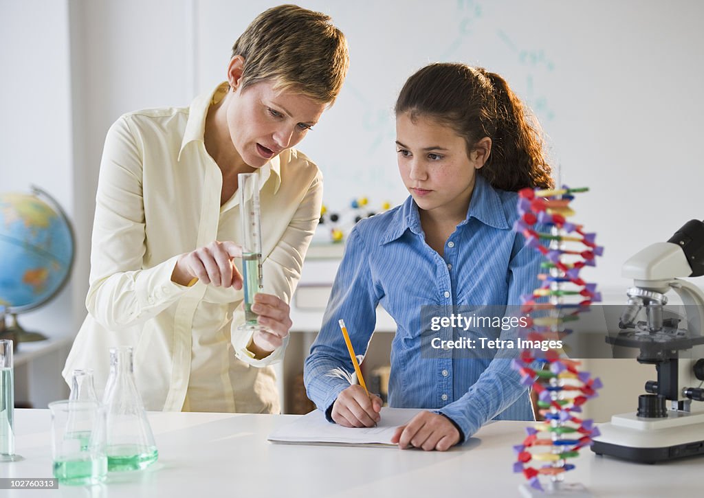 Teacher helping student in science lab