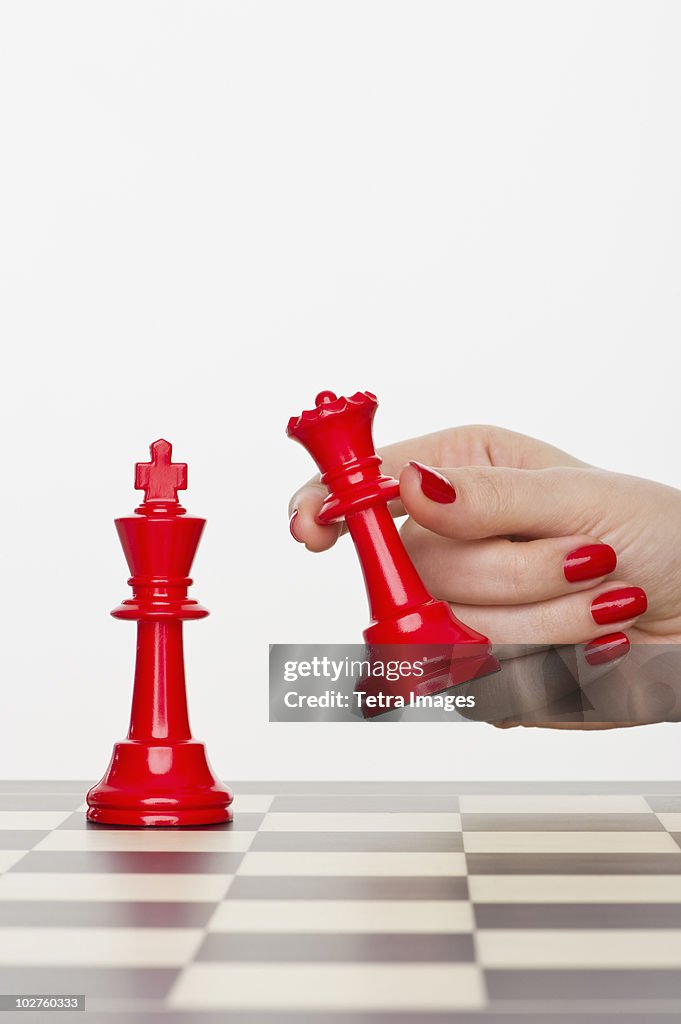 Hand holding red chess piece