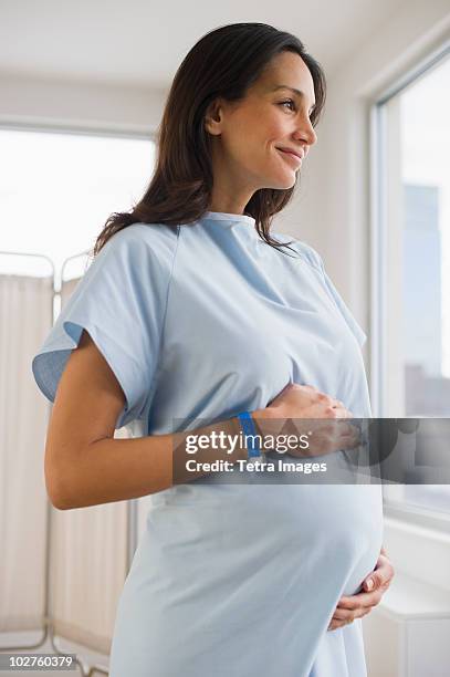 pregnant woman wearing hospital gown - hospital gown fotografías e imágenes de stock