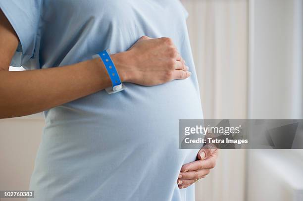 pregnant woman wearing hospital gown - hospital gown imagens e fotografias de stock