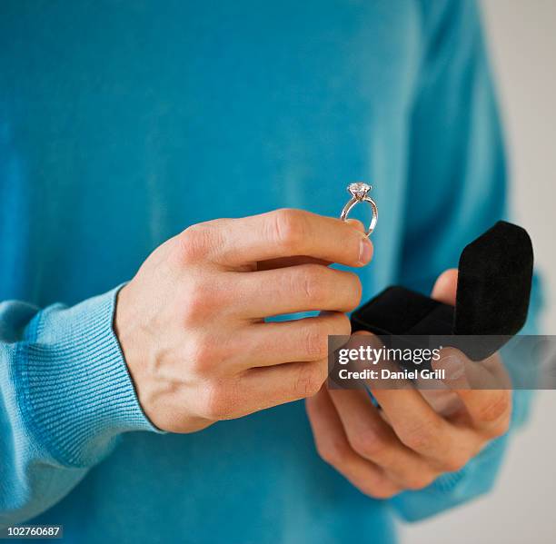 man holding engagement ring - engagement ring box - fotografias e filmes do acervo