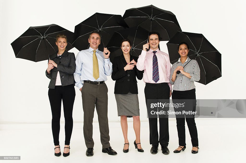 Happy business people with umbrellas