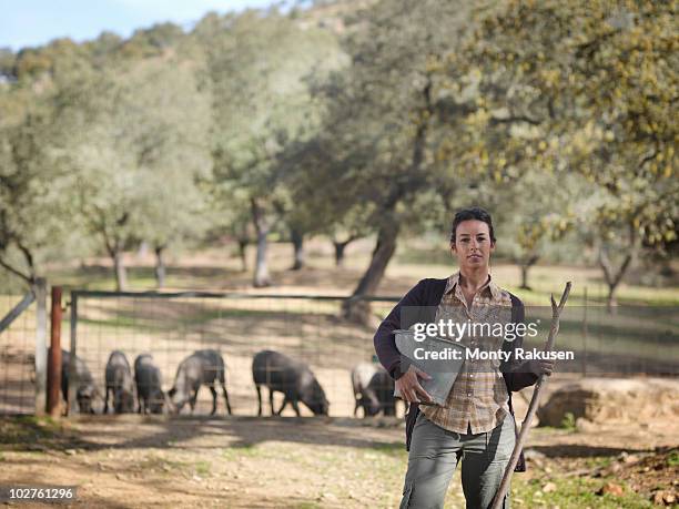 woman on farm holding bucket and stick - andalucia stock pictures, royalty-free photos & images