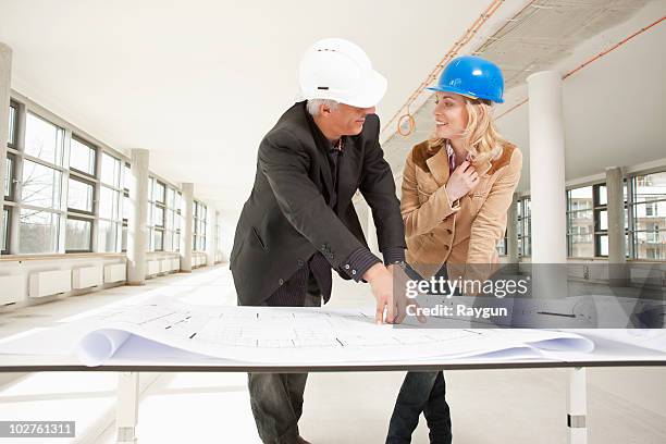 two architects checking plans of site - technische zeichnung anschauen stock-fotos und bilder