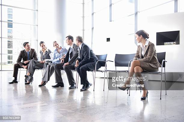 woman sitting alone separate from group - exclusion stock-fotos und bilder