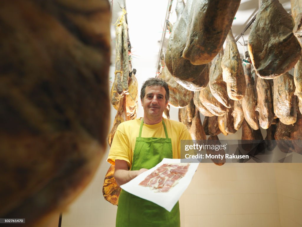 Man holding freshly sliced ham