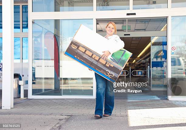 girl carrying new-bought tv out of store - carrying tv stock pictures, royalty-free photos & images