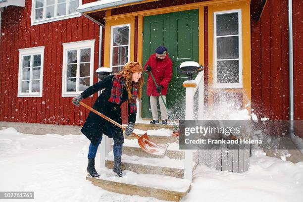 young woman helping older lady - shoveling snow stock pictures, royalty-free photos & images