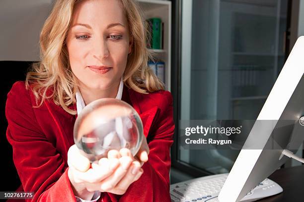 businesswoman holding a crystal ball - bola de cristal fotografías e imágenes de stock