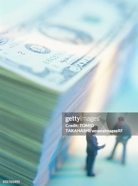two small figurines and a stack of money - handshake blue background stock illustrations