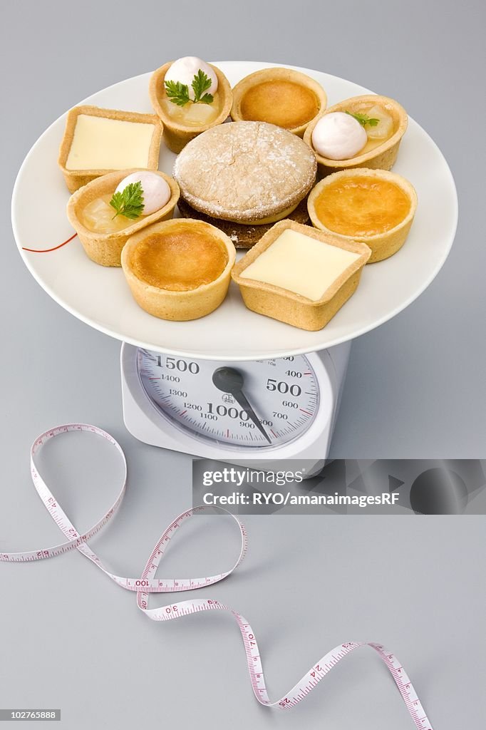 Variety of tarts and desserts being measured on a weight scale