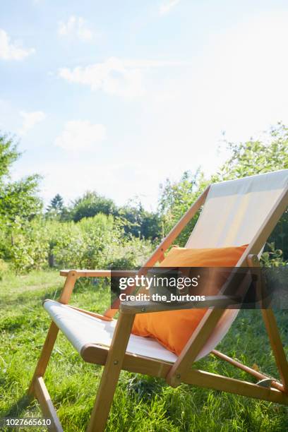 deck chair and enamel cup in the garden, sun painted on the cup - sunbed stock pictures, royalty-free photos & images