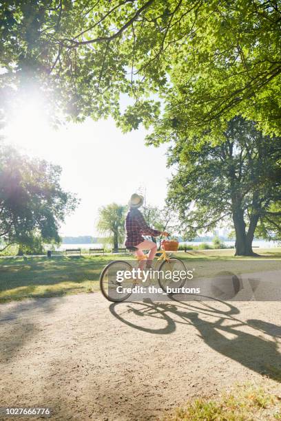 woman cycling with beachcruiser bicycle in public park - hamburg germany stockfoto's en -beelden