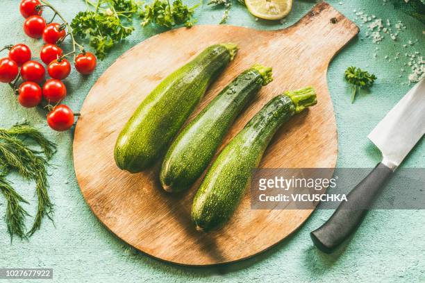 whole zucchini on cutting board with knife - calabacín fotografías e imágenes de stock