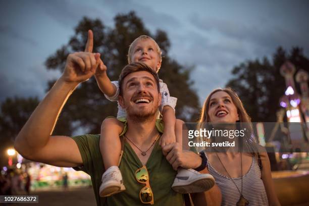 family enjoy on summer festival - carrying on shoulders stock pictures, royalty-free photos & images