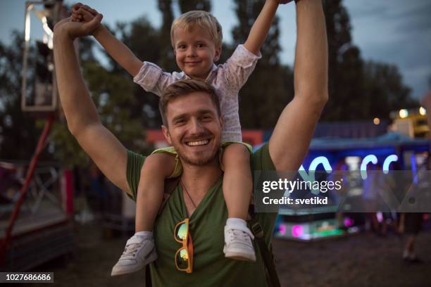 family enjoy on summer festival - carrying on shoulders stock pictures, royalty-free photos & images